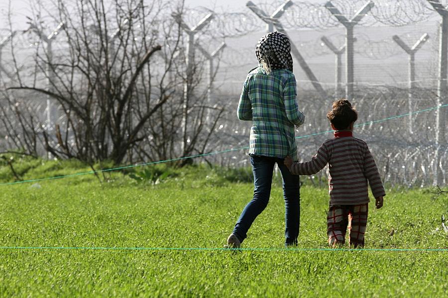 Flüchtlinge vor einem Grenzzaun (Archiv)